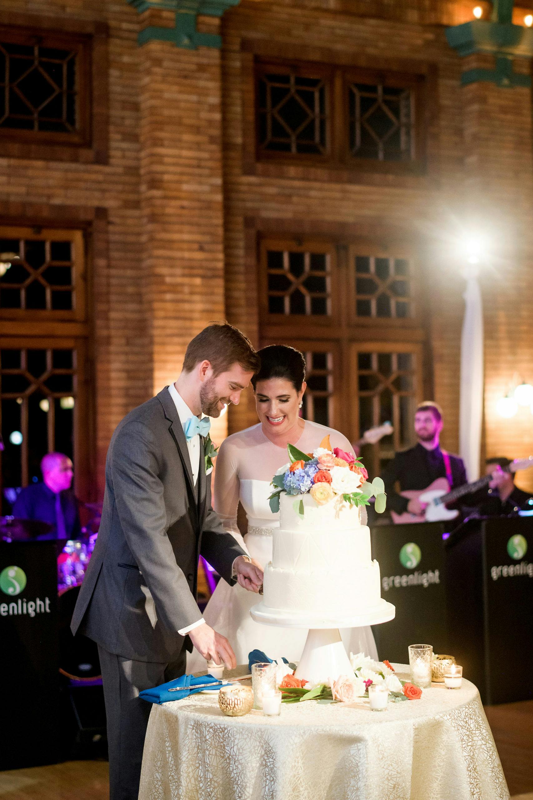 Bride and Groom Cut Cake at Wedding Planned by Storybook Weddings & Events at Café Brauer at Lincoln Park Zoo | PartySlate