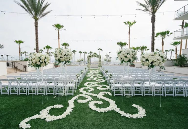 Outdoor Wedding with Floral Aisle Decor in Waterfront Beach Resort Hilton Hotel in Huntington, CA | PartySlate