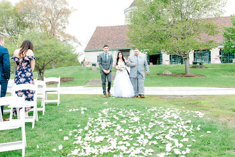Bride given away at intimate lakeside wedding surrounded with petals at Promontory Point in Chicago, IL | PartySlate