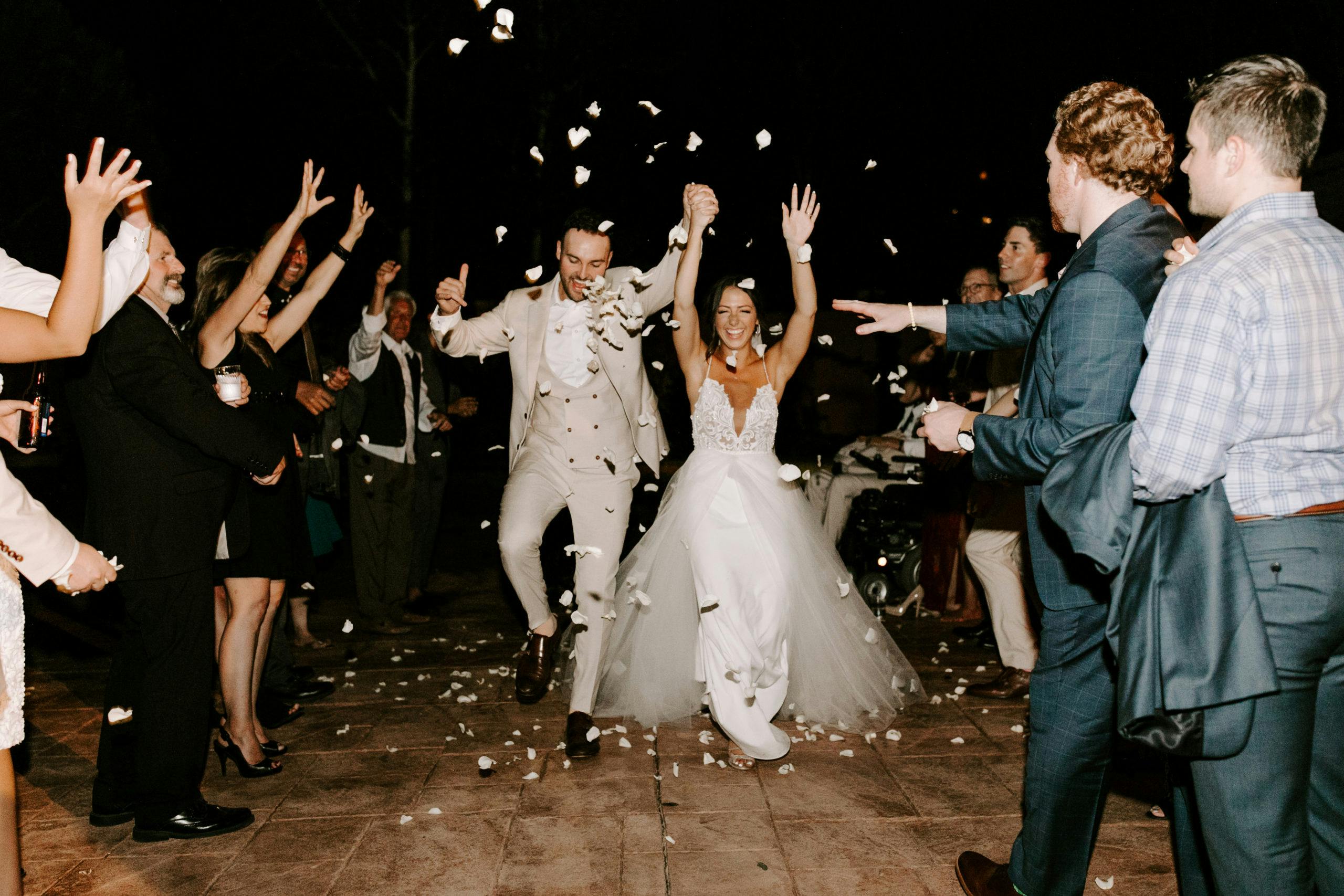 Guest throwing confetti at bride groom during reception | PartySlate