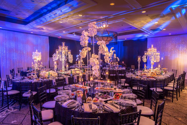 Blue uplit wedding reception with orchid décor at Concorde Banquets in Kildeer, IL | PartySlate