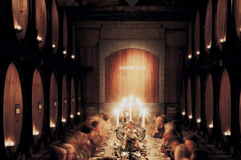 Merryvale Vineyards’ Historic Cask Room hosting a candle-lit dinner with guests engaged in conversation| PartySlate