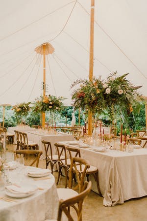Pole tent wedding with greenery | PartySlate