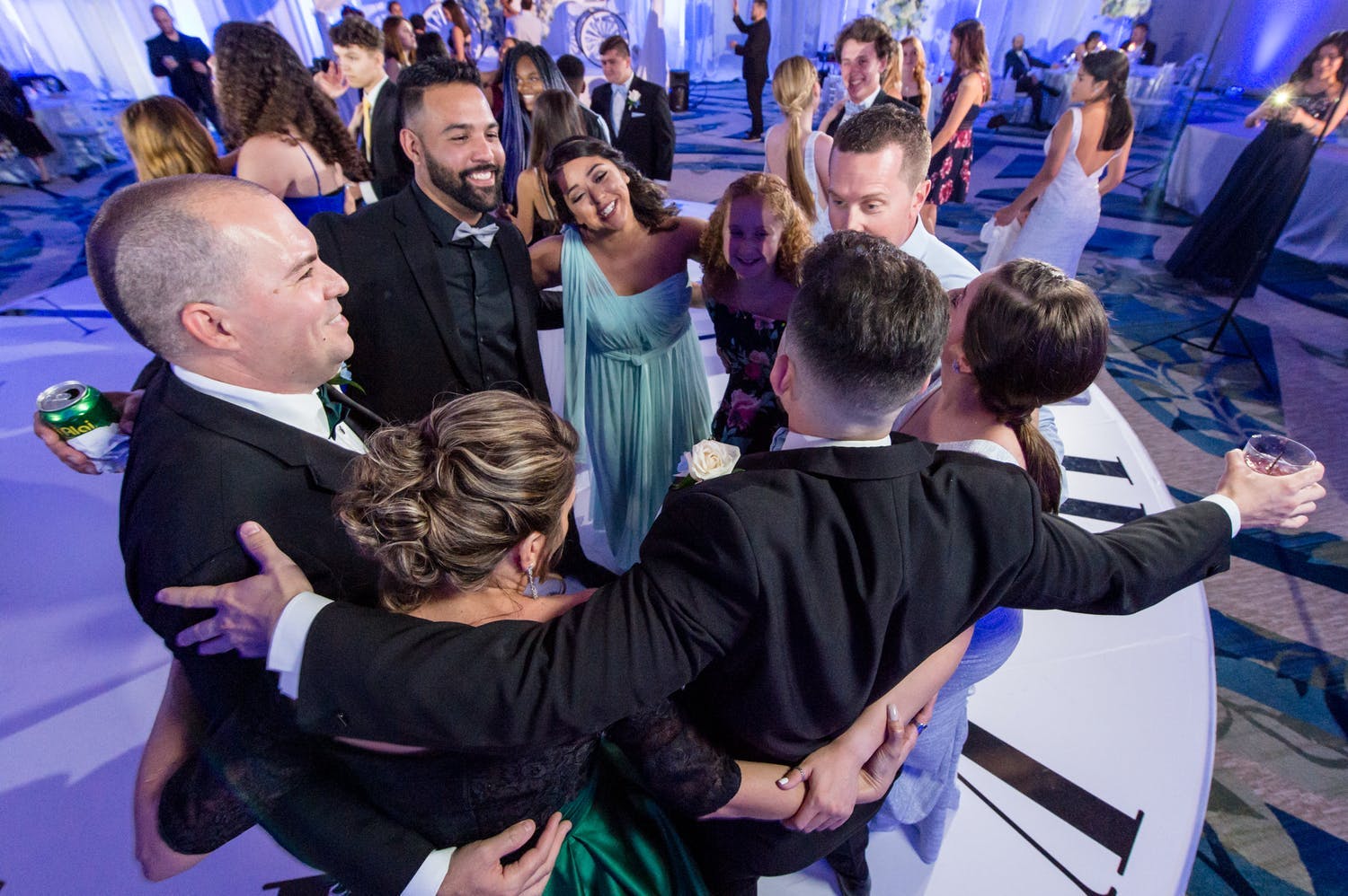 Friends and family hug on dance floor at quinceañera | PartySlate
