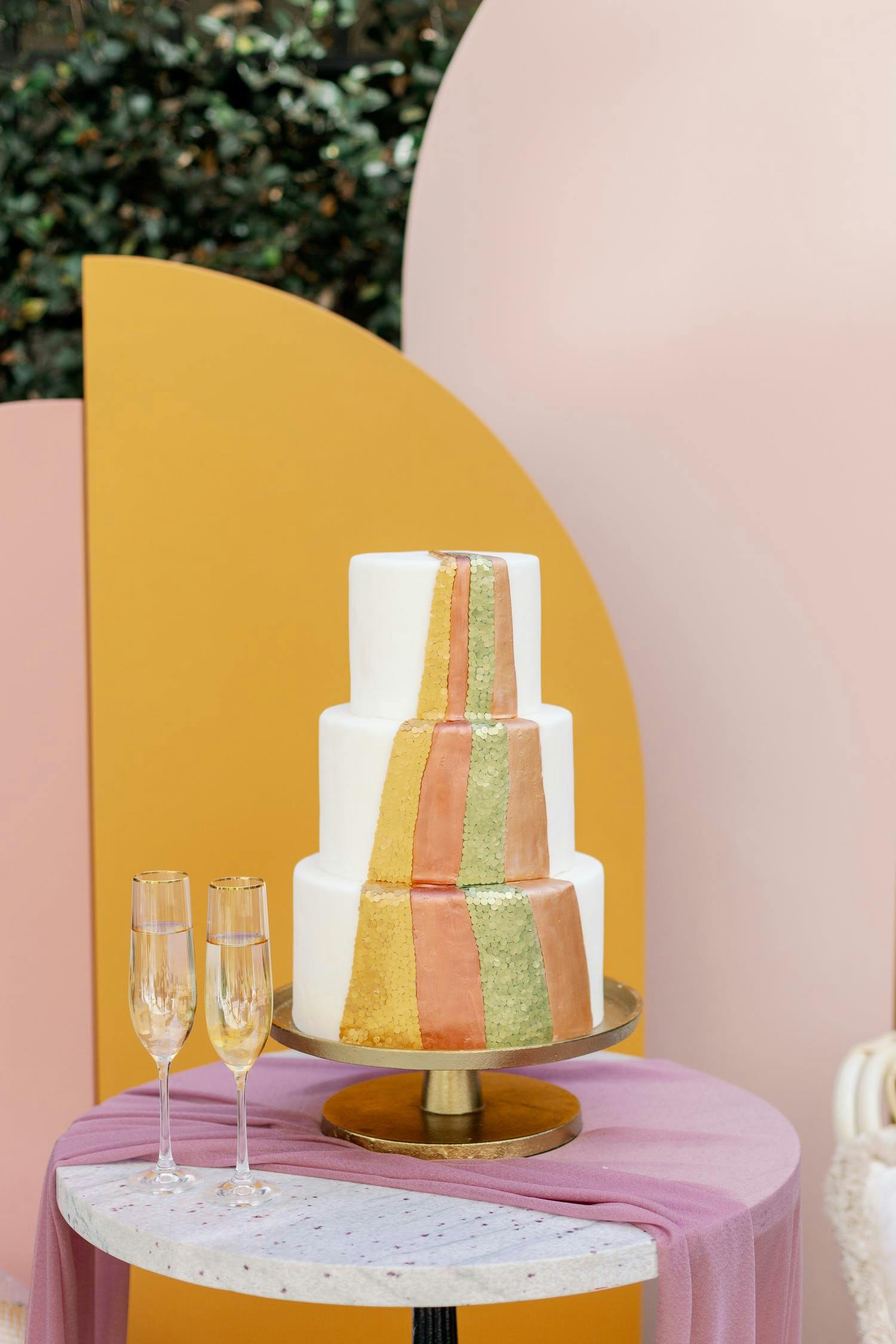 Three tier boho, 70s style wedding cake with multiple bright colors | PartySlate