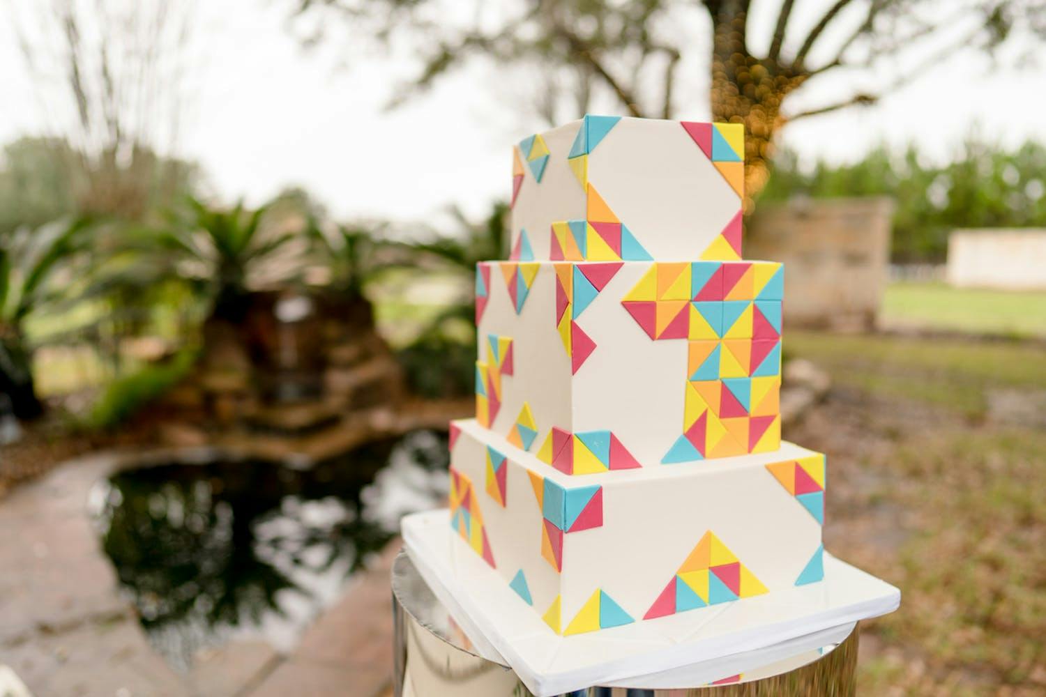 Three tier square wedding cake with multi-color tangram designs | PartySlate