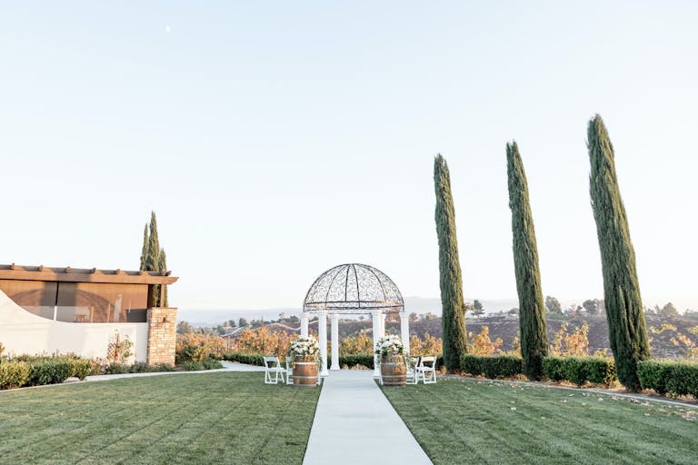 Perfectly manicured lawn with white aisle and dome altar at Avensole Winery in Temecula, CA | PartySlate