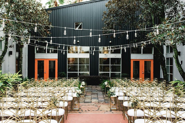 Outdoor wedding with string lights at the courtyard at 5226 ELM, one of PartySlate's favorite small Houston wedding venues | PartySlate
