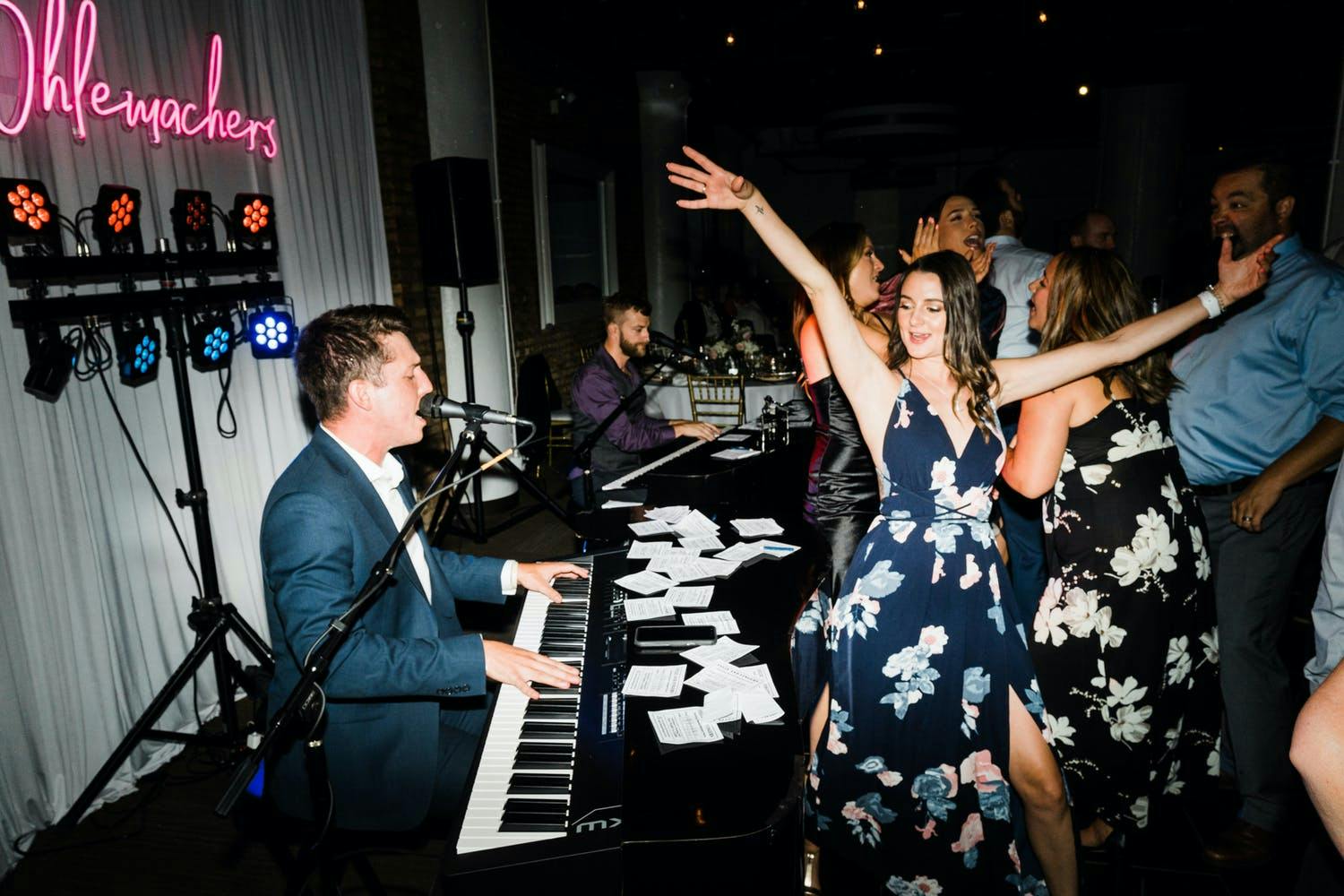 Wedding guest dances next to dueling pianos at wedding reception | PartySlate