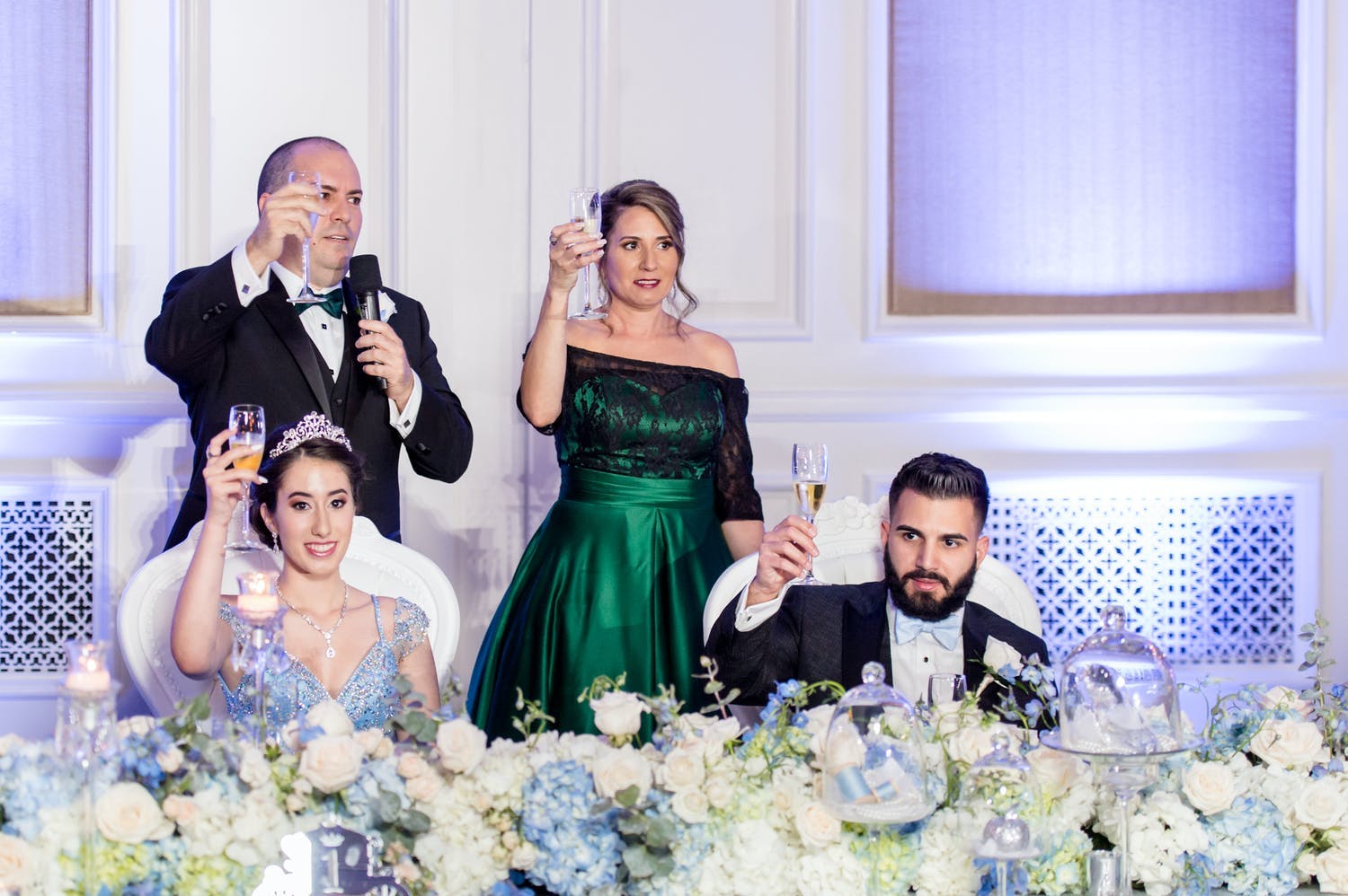 Parents and chambelan escort raise a toast, one of many common quinceañera traditions, for celebrant at fairytale reception | PartySlate