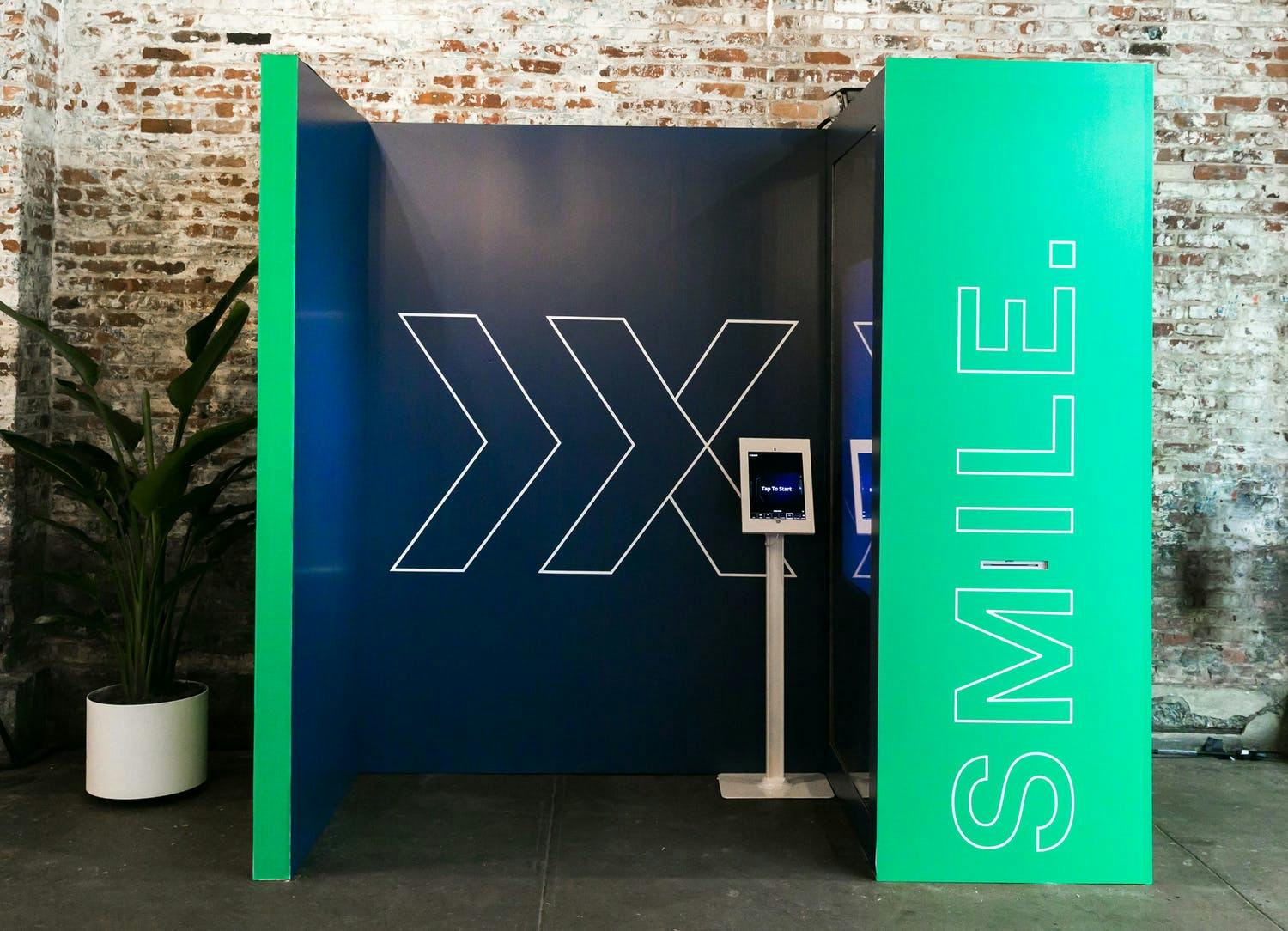 Corporate event with green and black selfie station with Now + Next branding design | PartySlate
