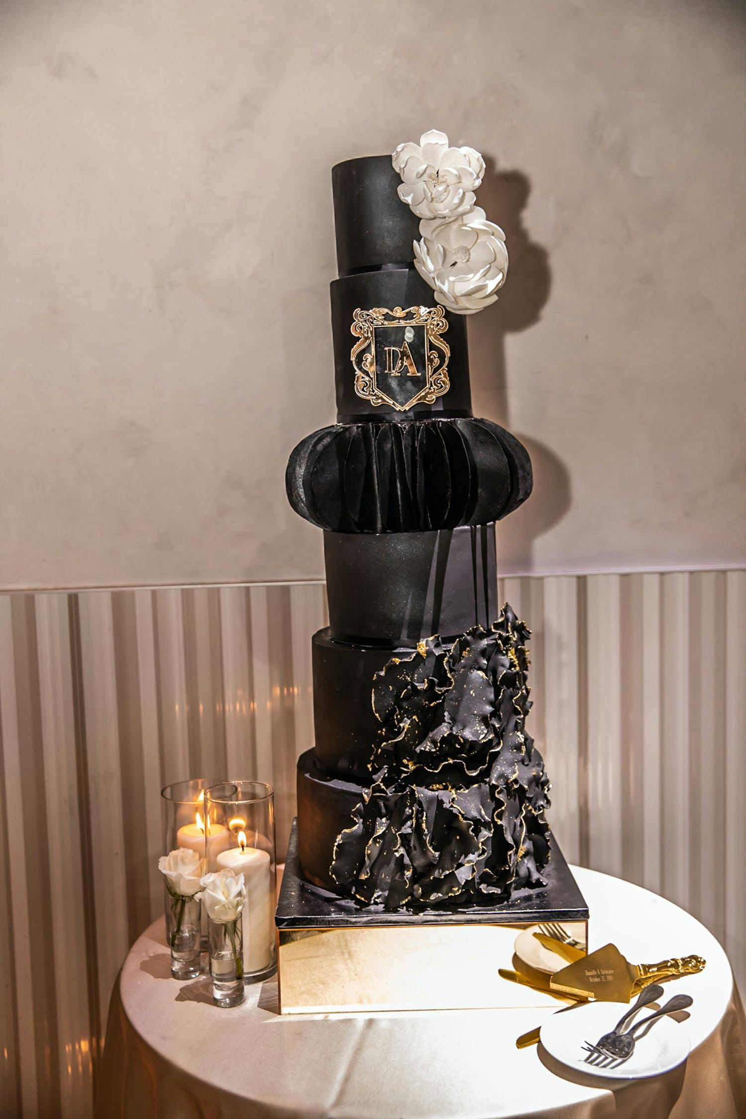 Tall black wedding cake with moody accents and designs | PartySlate