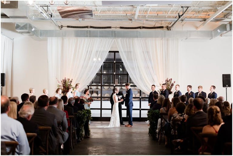 All-White Modern and Minimalist Wedding Ceremony at The Stave Room at American Spirit Works in Atlanta, GA | PartySlate