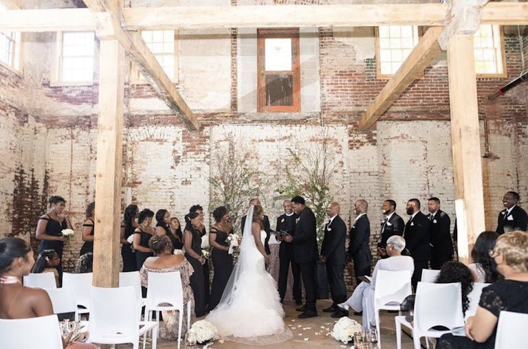 Indoor Wedding Ceremony with Minimal Greenery at Guardian Works at Echo Street West, an Industrial Raw Event Space in Atlanta, GA | PartySlate