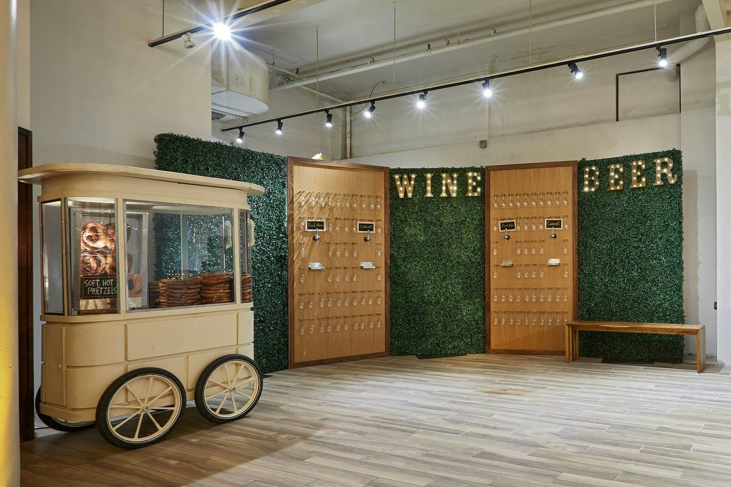 Self-serve wine and beer wall with boxwood backdrop | PartySlate