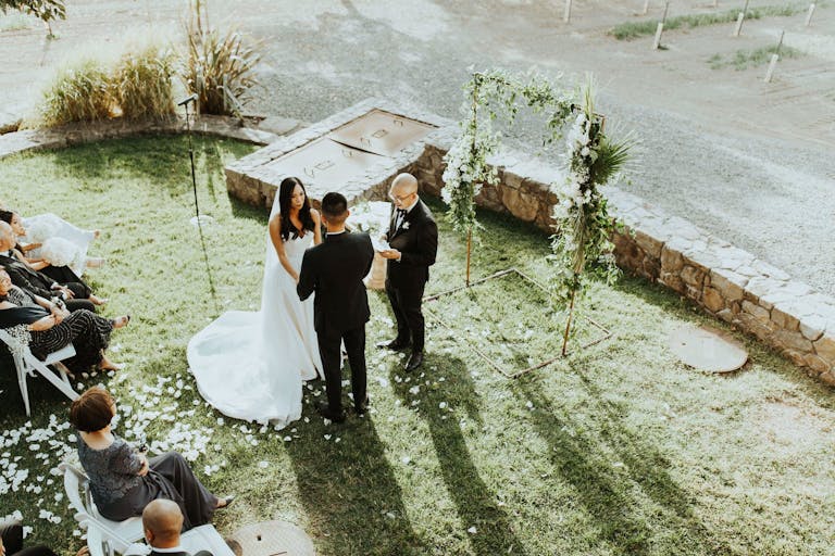 Bride and groom exchange vows at the end of a white petal blanketed aisle at Foley Sonoma, a California winery venue | PartySlate