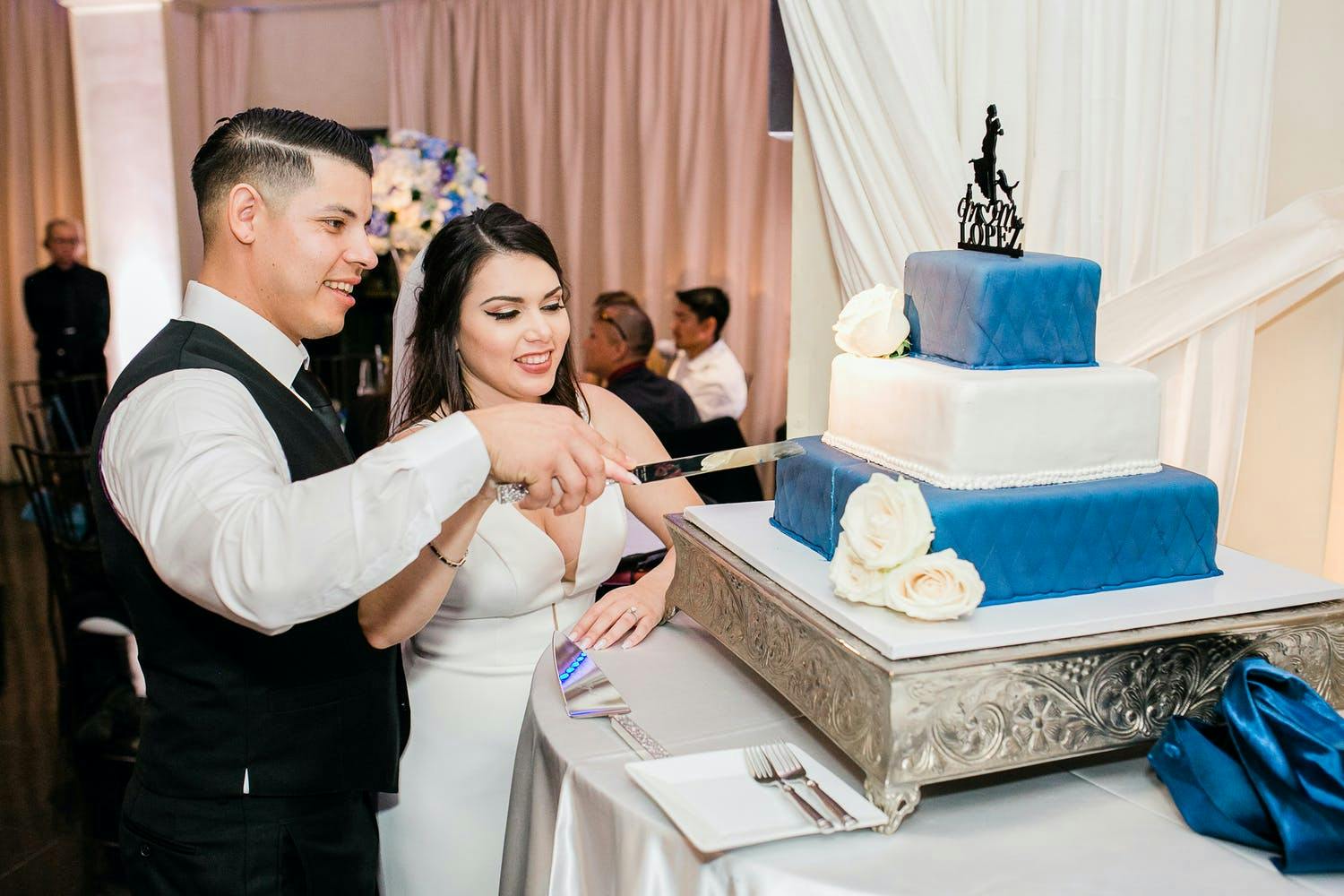 Three-tier wedding cake with dark blue on top and bottom and white in middle | PartySlate