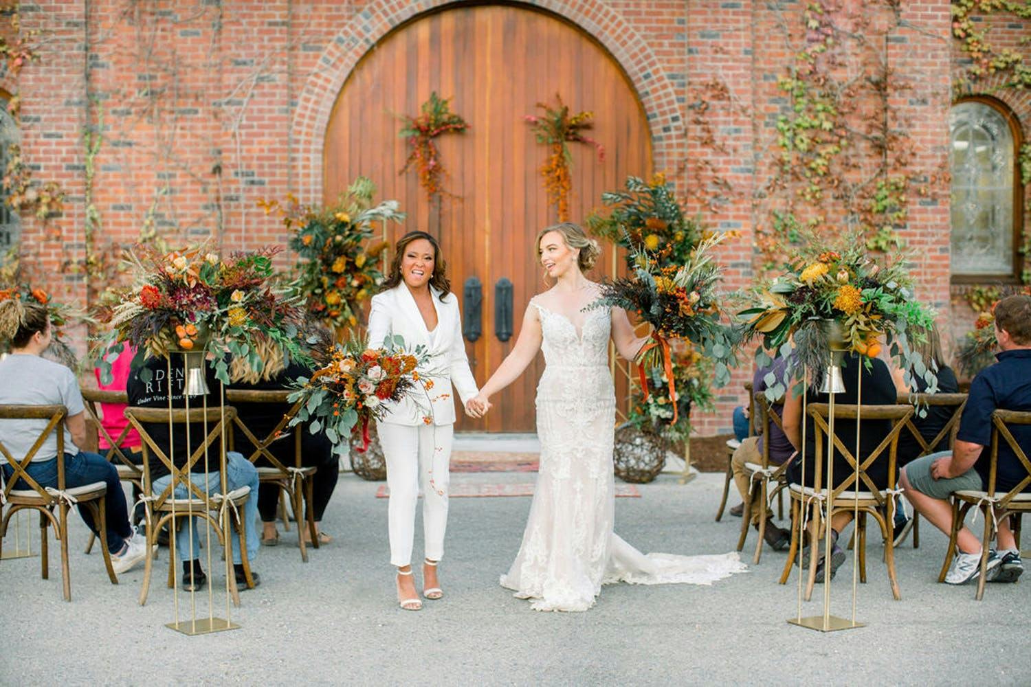 Two brides during recessional at boho-style vineyard micro wedding | Partyslate