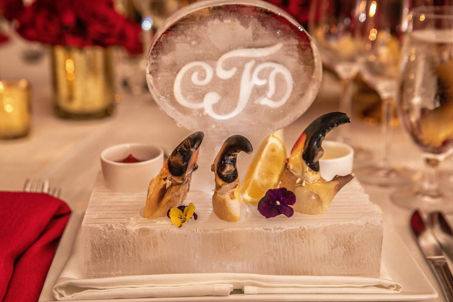 Individual mini shrimp cocktail, monogrammed ice sculpture on dinner plate at micro wedding | PartySlate