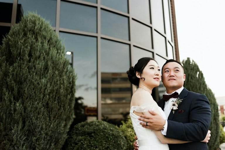 First Look fo Bride and Groom in Front of Glass Modern Building | PartySlate