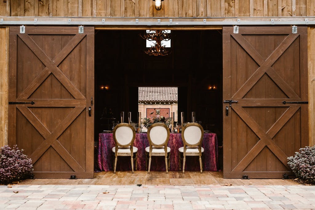 Intimate barn wedding with plum-colored linen and white seating | PartySlate
