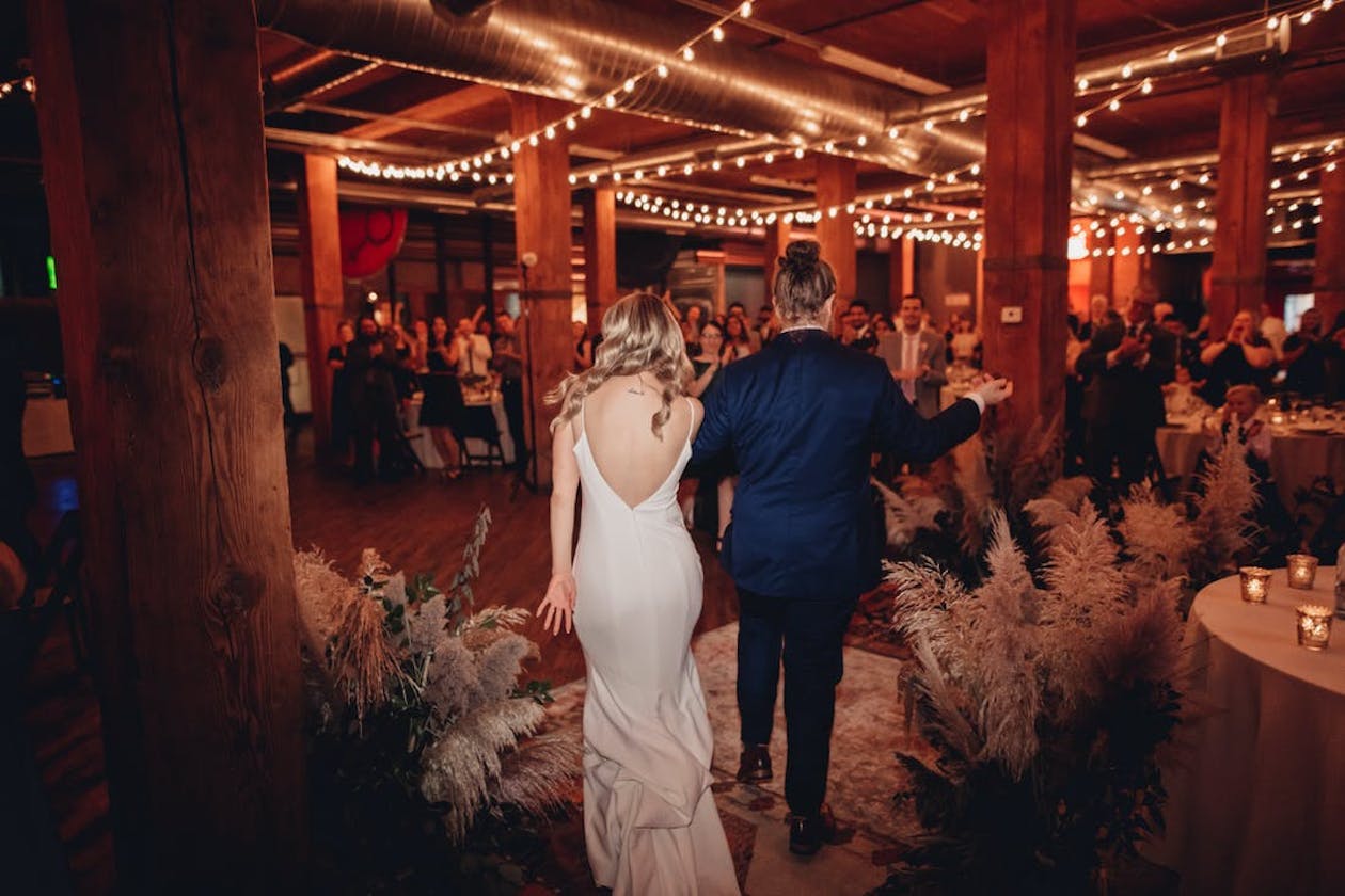 Couple walks into Lacuna Events by LM with overheard string lights | PartySlate