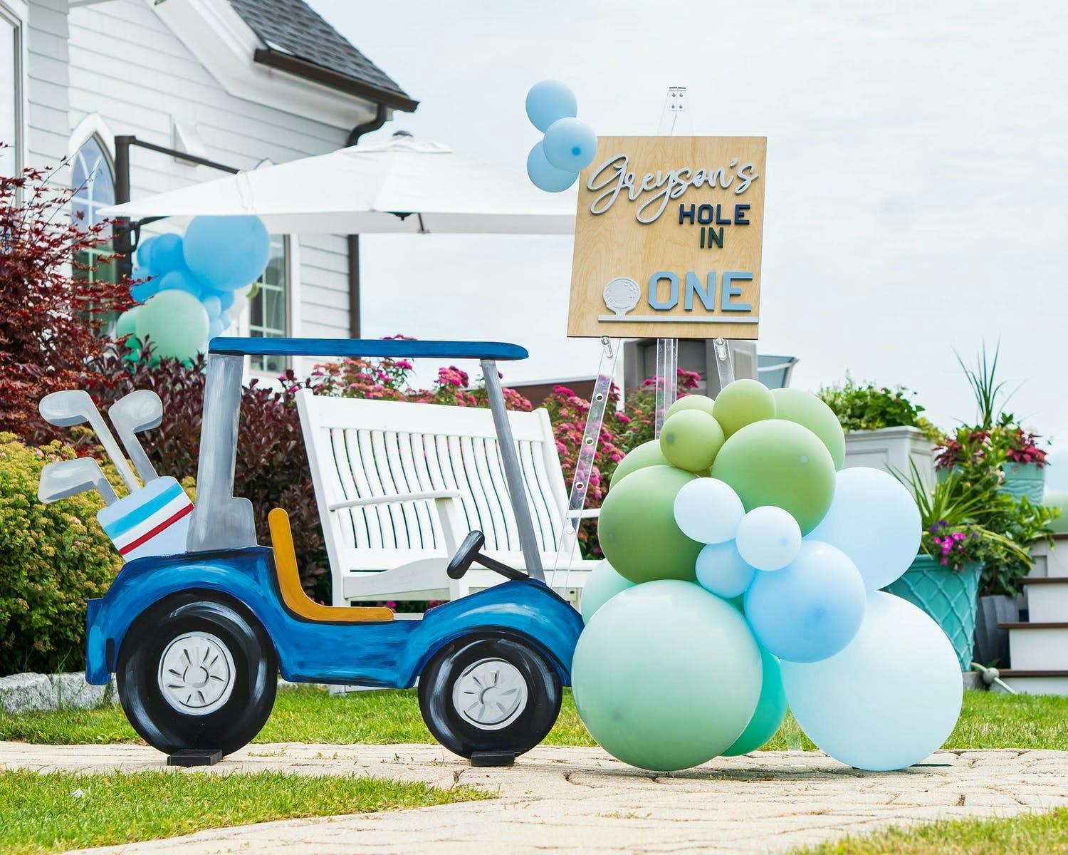 Golf cart paper cutout with pastel blue and green matte balloons | PartySlate