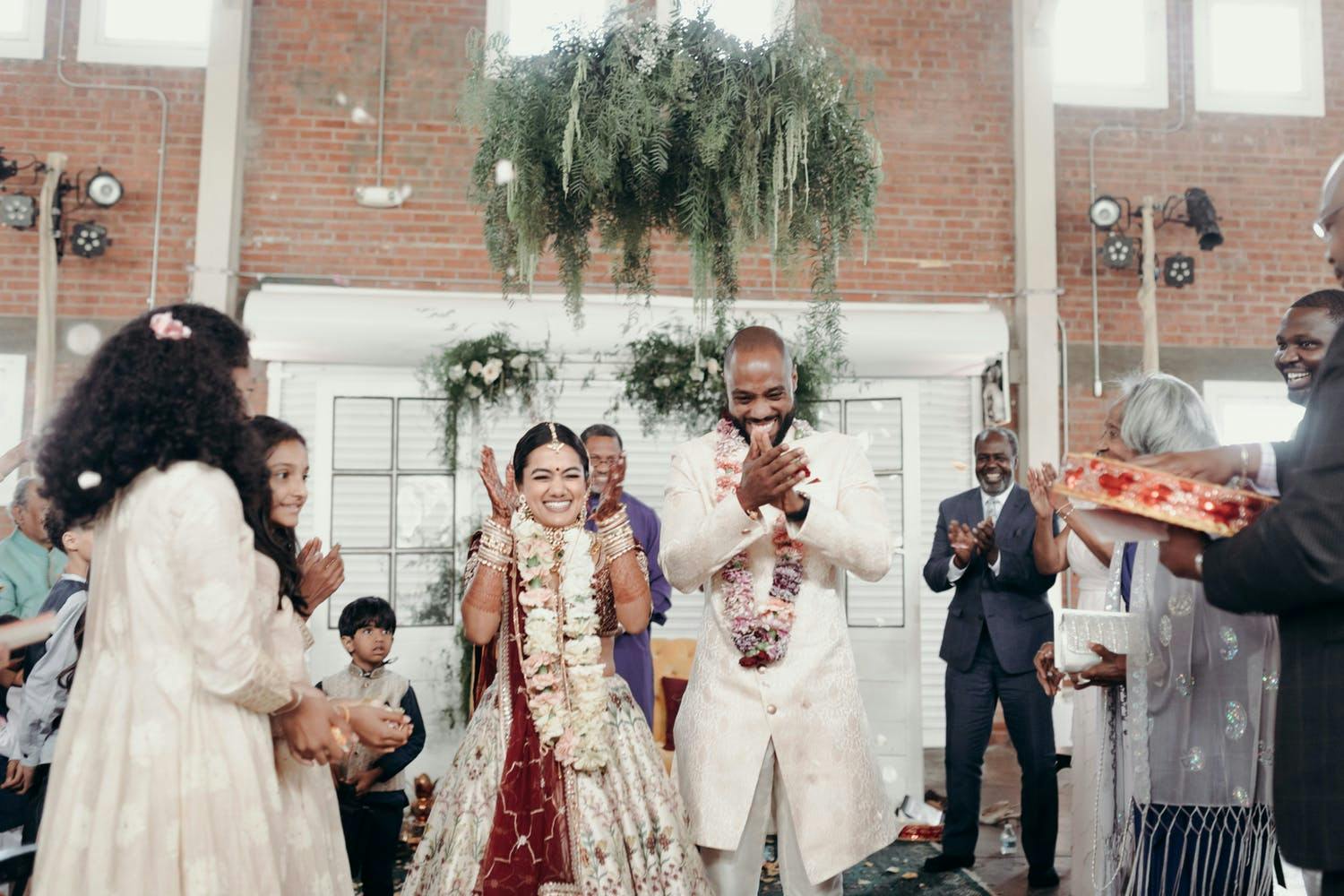 Recessional at South Asian wedding with overhanging organic greenery | PartySlate