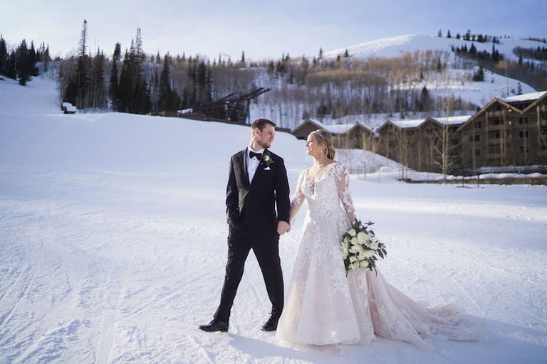 White Winter Wedding with Couple Walking in the Snowy Mountains | PartySlate