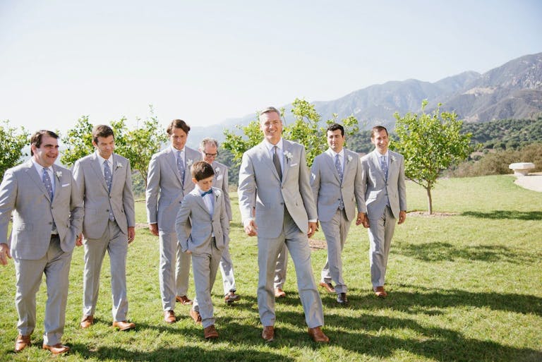 Groom and Groomsmen Walking with The Mountains Behind Them | PartySlate