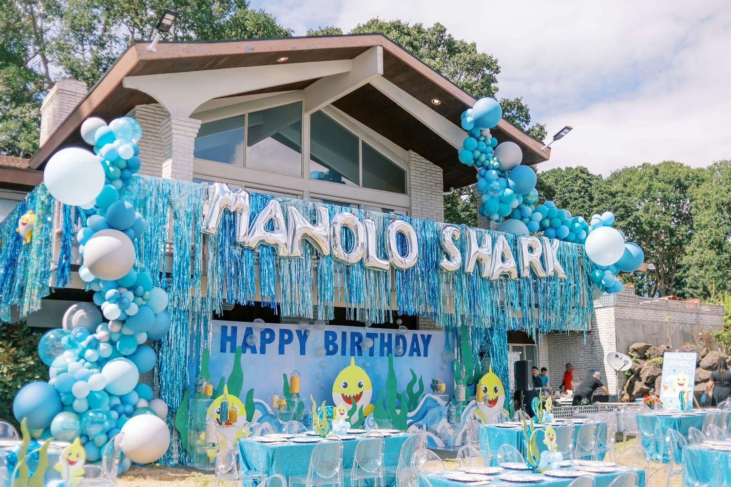 Entire facade of house decorated in blue and silver streamers and balloons for Baby Shark themed birthday party | PartySlate