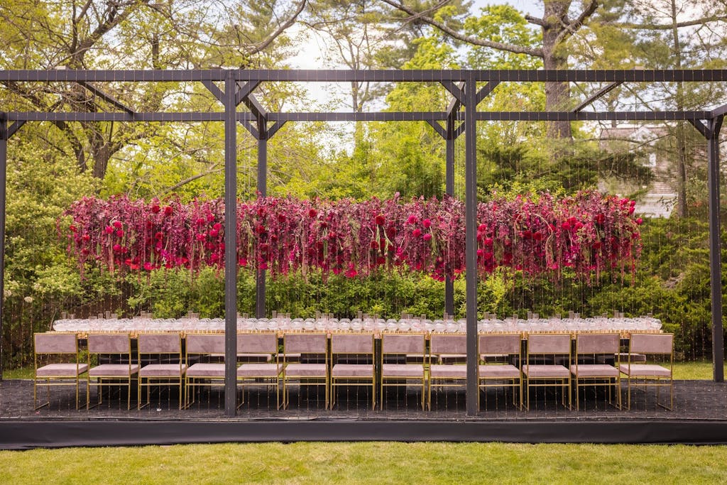 Outdoor wedding tablescape  with elevated bright pink floral centerpieces | PartySlate