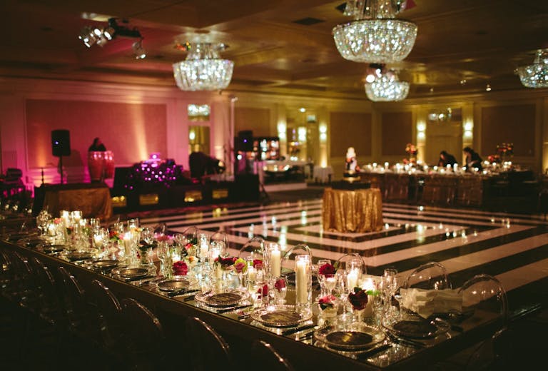 Starlight Ballroom at Fairmont Miramar Hotel & Bungalows with black and white dance floor, mirrored tabletops, pink florals, and candlelight | PartySlate