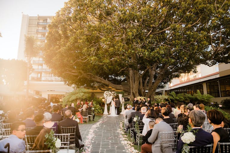 Golden Hour Wedding Ceremony Under A Big Tree In The Courtyard of Fairmont Miramar Hotel | PartySlate