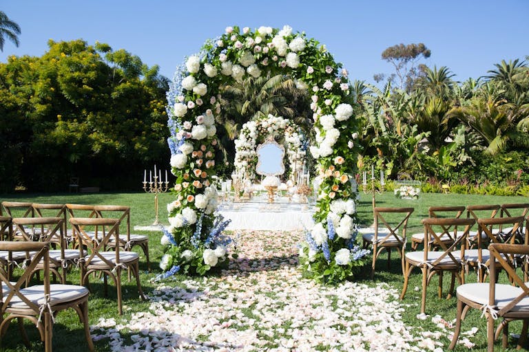 Green and White Floral Arches Lining The Outdoor Wedding Aisle | PartySlate