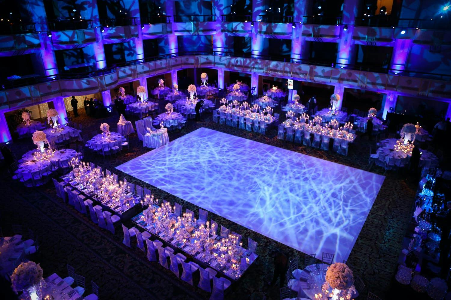 Traditional South Asian wedding at Waldorf Astoria New York with blue uplighting and dance floor that looks like the ocean | PartySlate