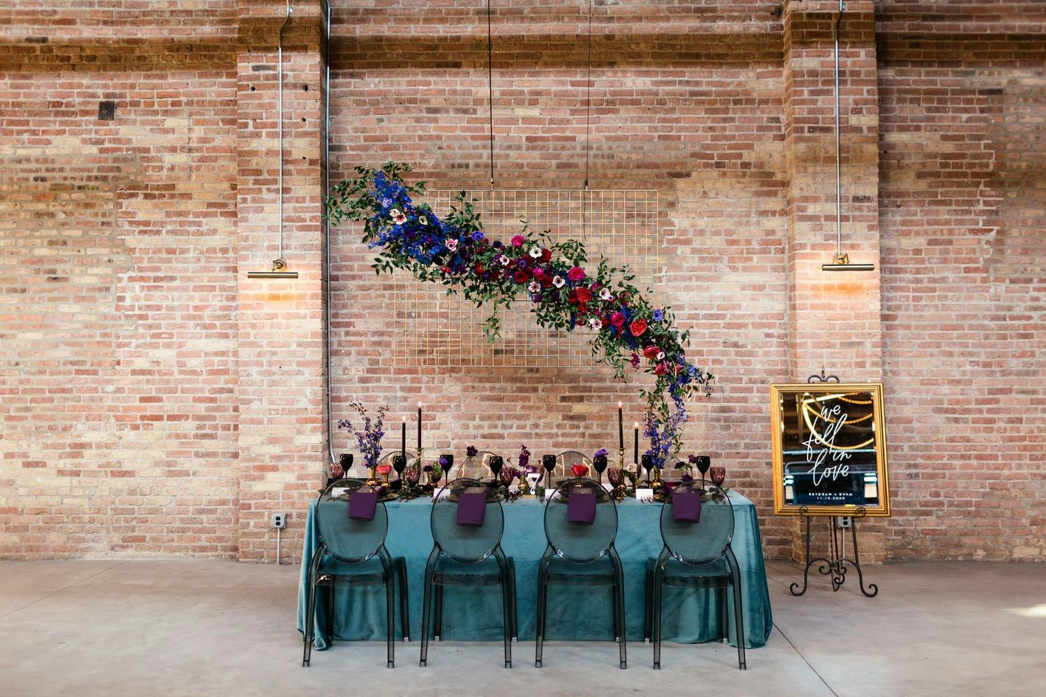 Minimalist wedding at WildmanBT with floating floral installation over tablescape in moody colors | PartySlate
