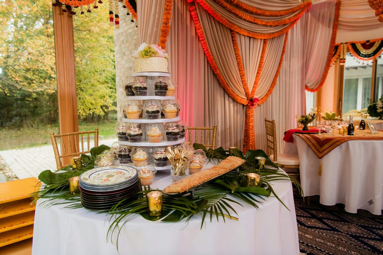 Small wedding cake with individuall wrapped cupcakes serving as bottom four tiers | PartySlate
