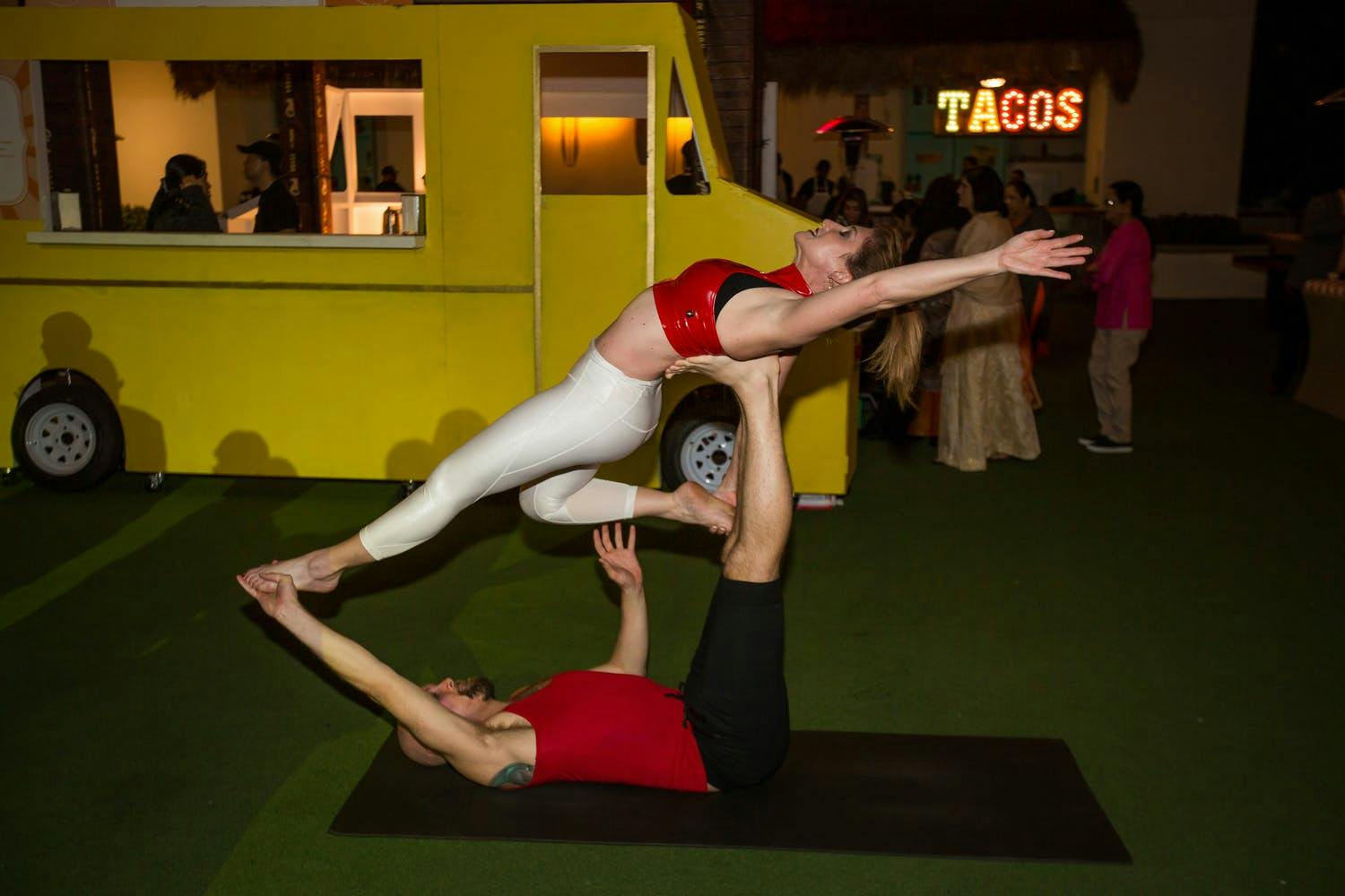 Cirque du Soleil Entertainment in front of yellow food cart at South Asian wedding | PartySlate