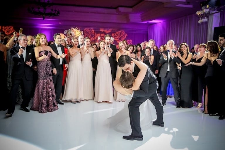 Couple Kissing While Guests Cheer at Colorful Wedding at The Ritz Carlton South Beach | PartySlate