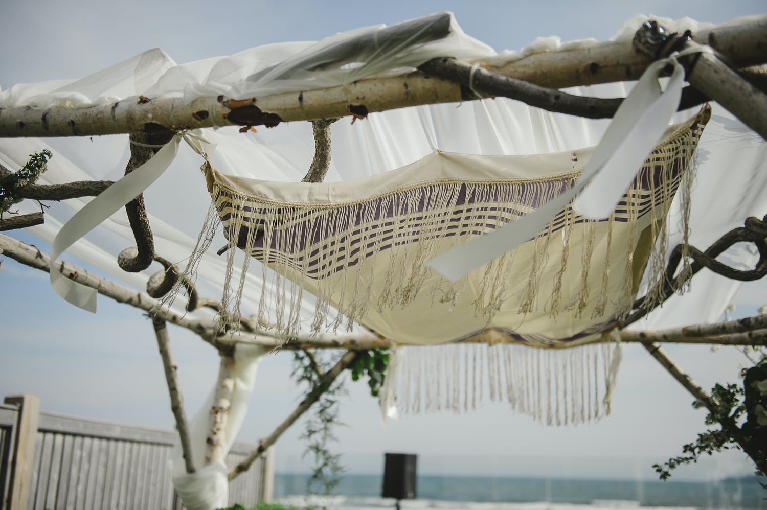 Beachside chuppah crafted from delicate branches | PartySlate