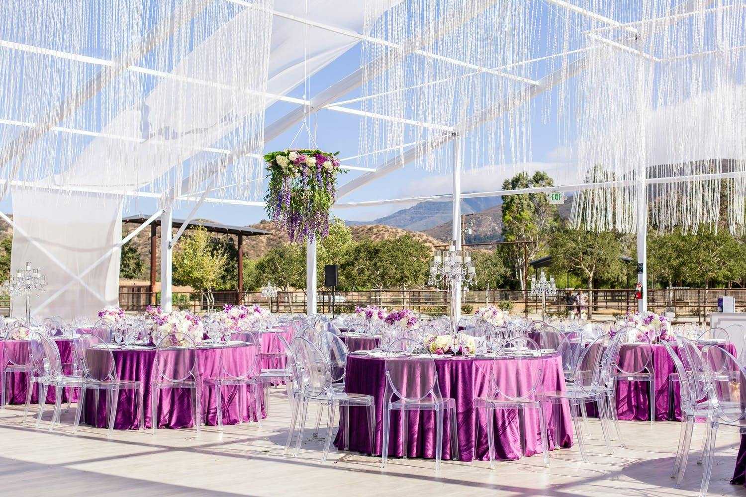 Transparent tented wedding with purple linen and suspended crystal fringe | PartySlate