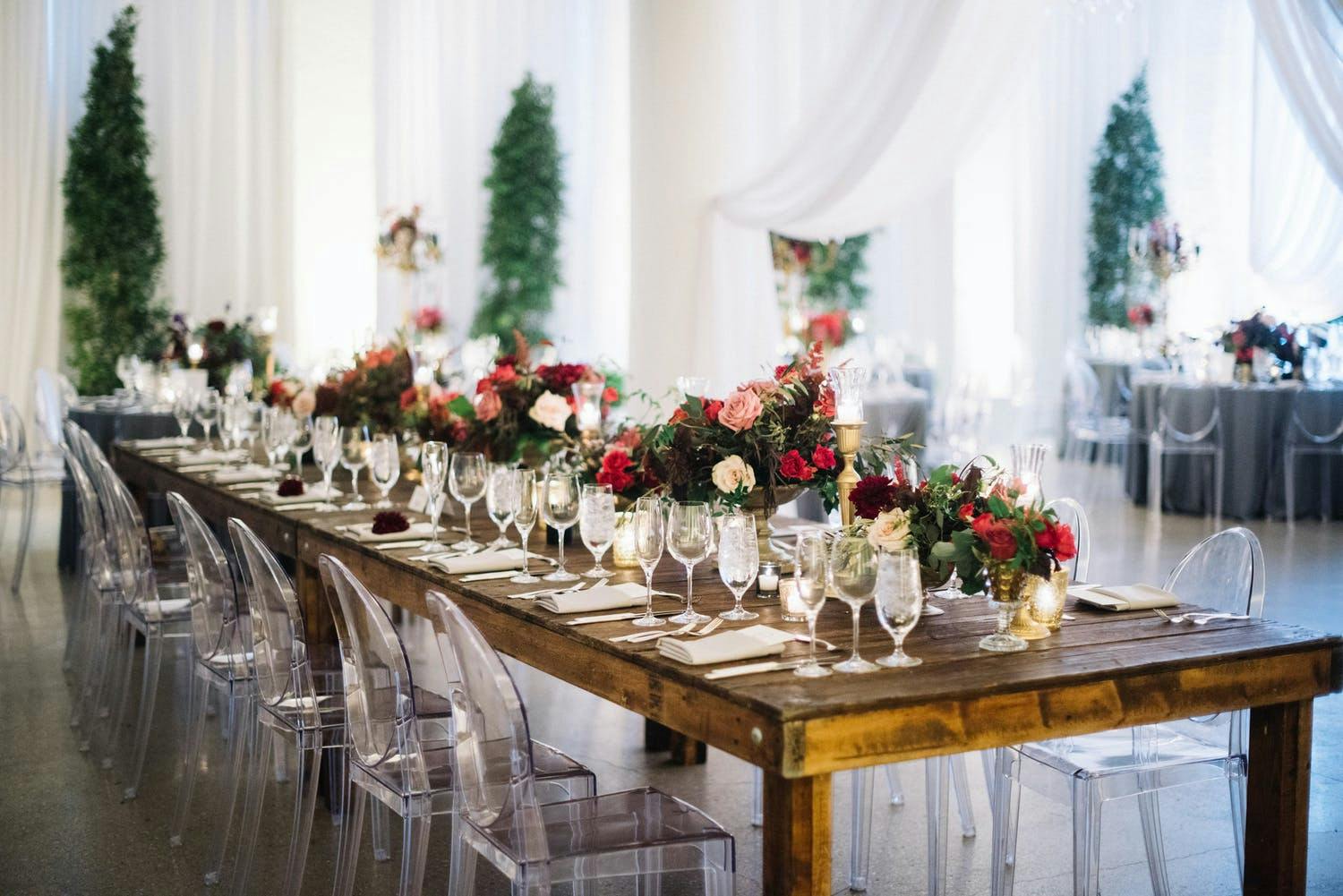 Rustic winter wedding table with pink and red floral centerpieces | PartySlate