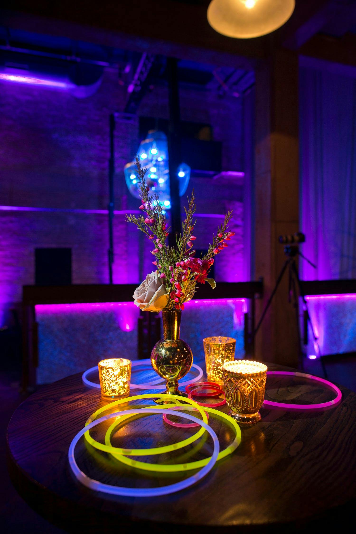 Wedding cocktail table with glow in the dark necklace décor | PartySlate