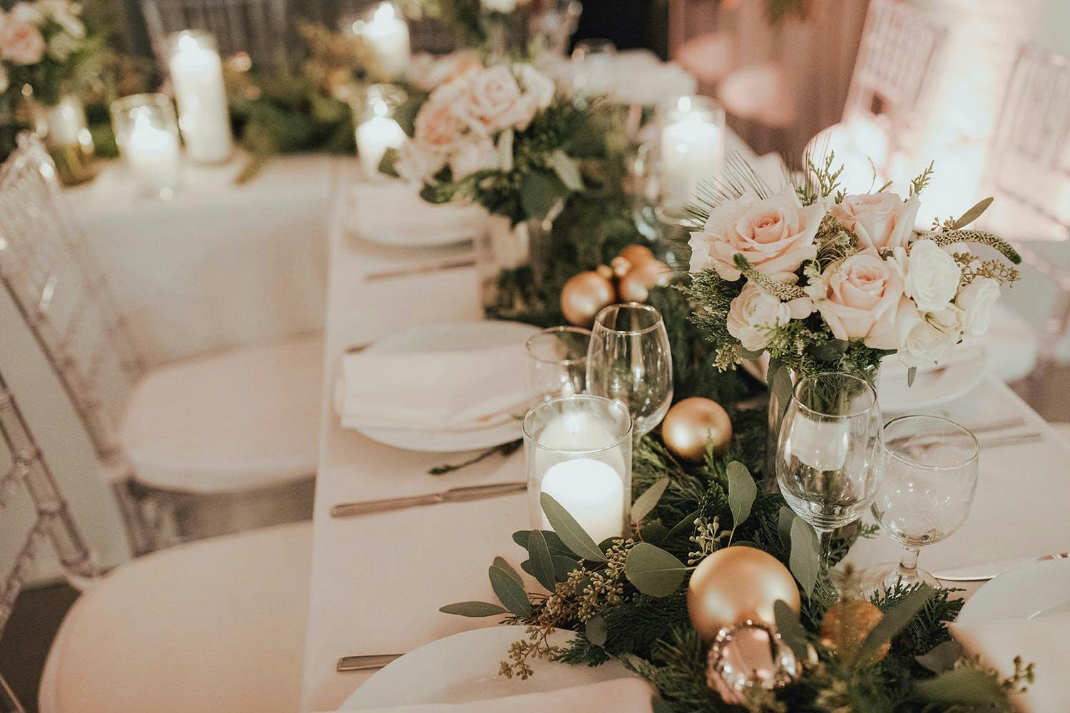 Blush winter wedding table with greenery and gold ornaments | PartySlate