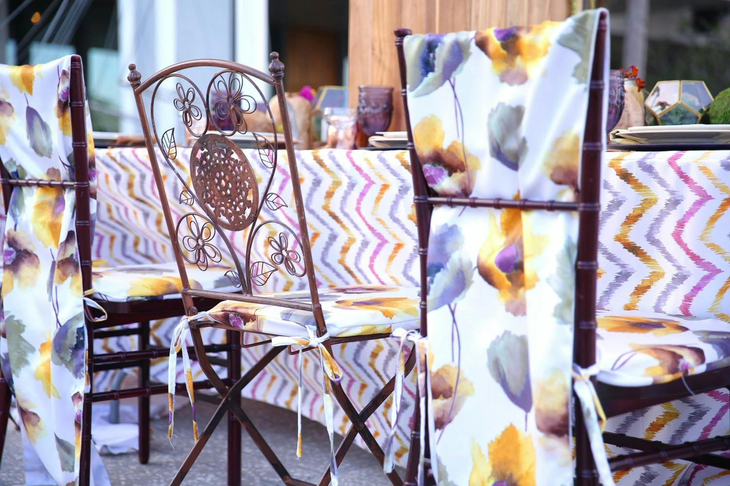 Bohemian wedding with purple and yellow floral seating drapery | PartySlate