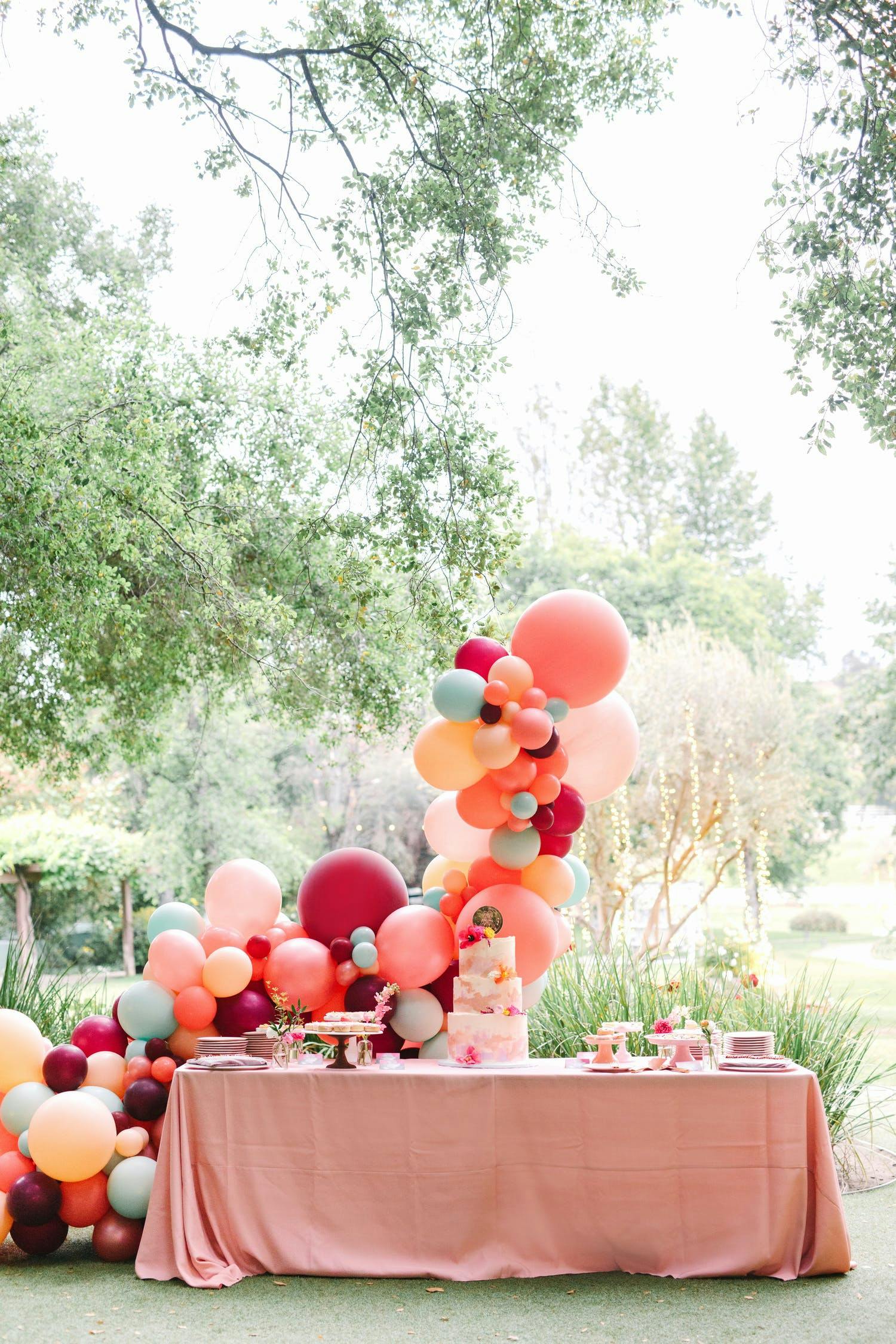 Whimsical balloon arch at outdoor wedding | PartySlate