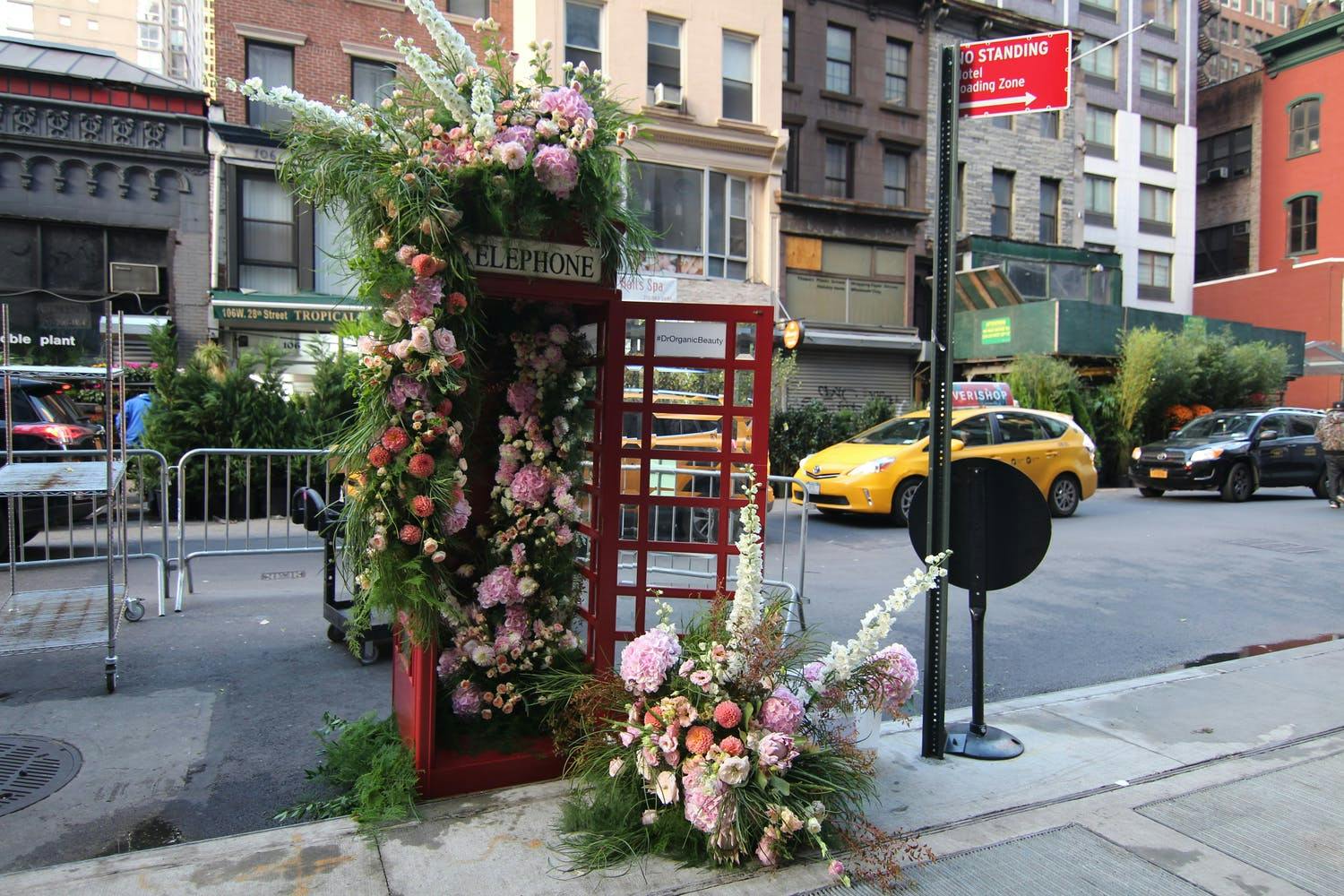 Vintage Bristish telephone booth overflowing with flowers for launch event | PartySlate