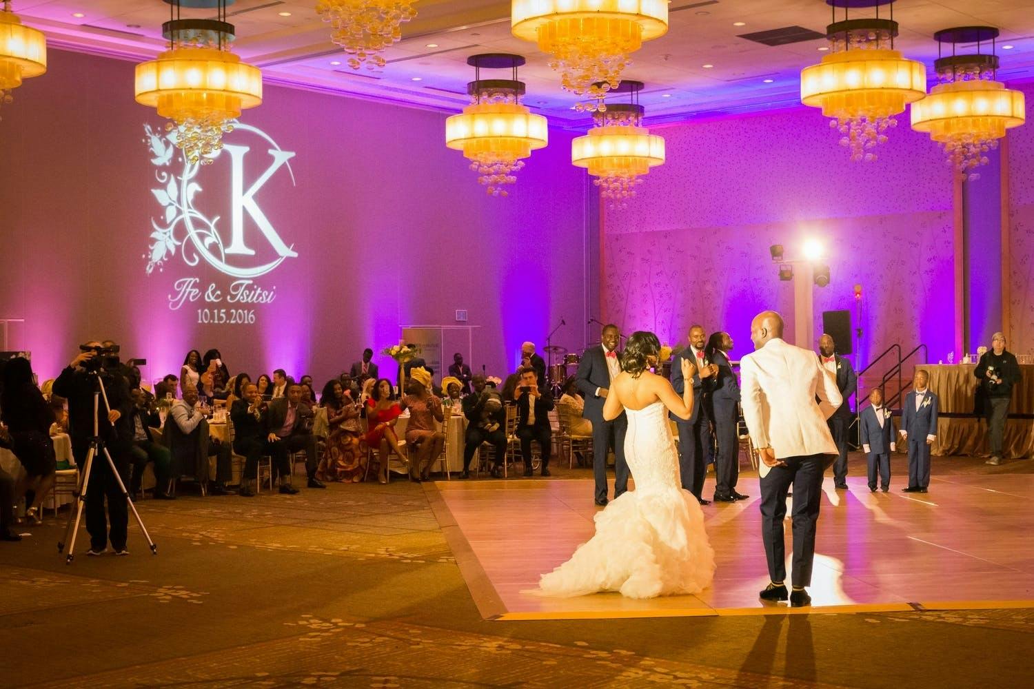 Ballroom wedding with dance floor, purple uplighting, and floral monogrammed gobo | PartySlate