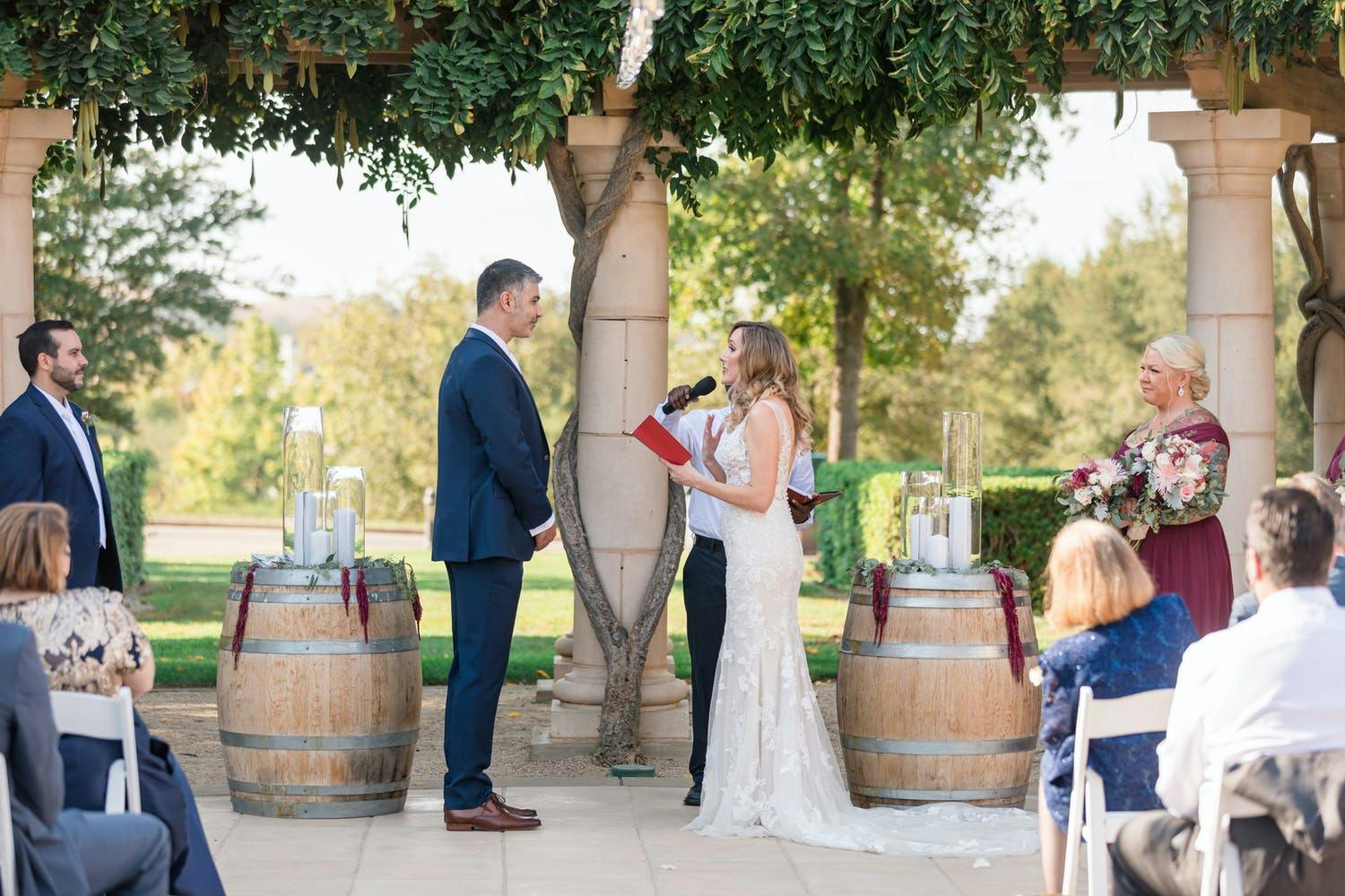 Rustic outdoor wedding ceremony with two barrels lining altar | PartySlate